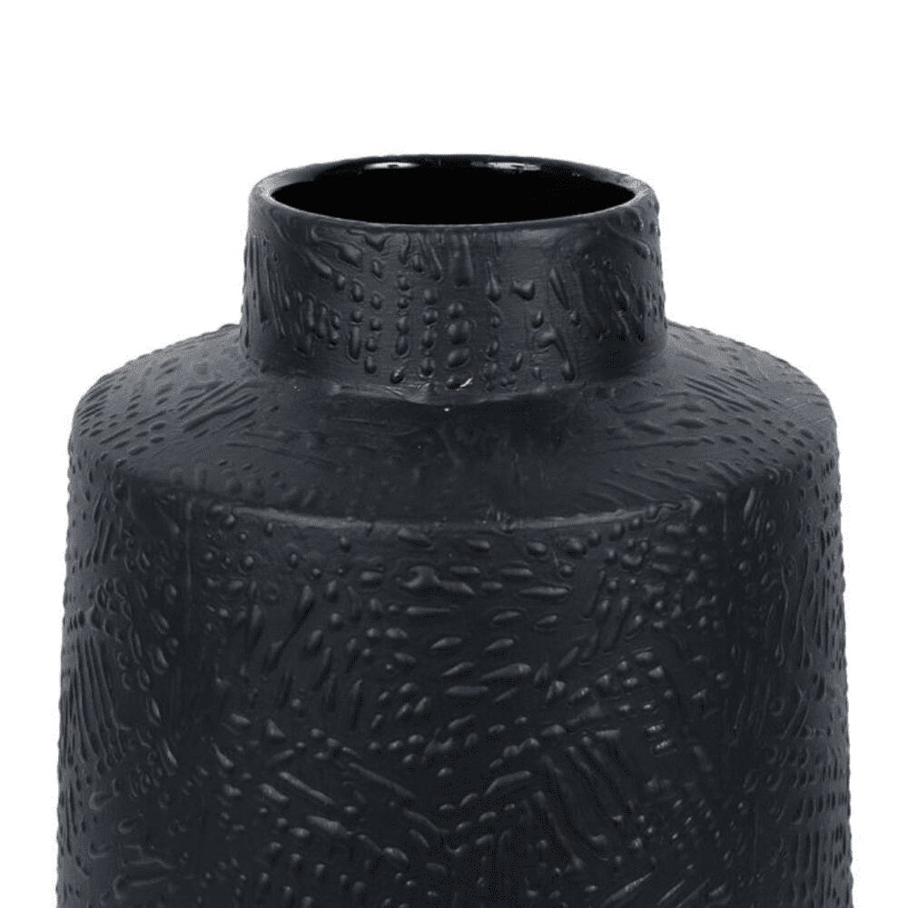 vase noir avec des motifs en relief sur fond blanc